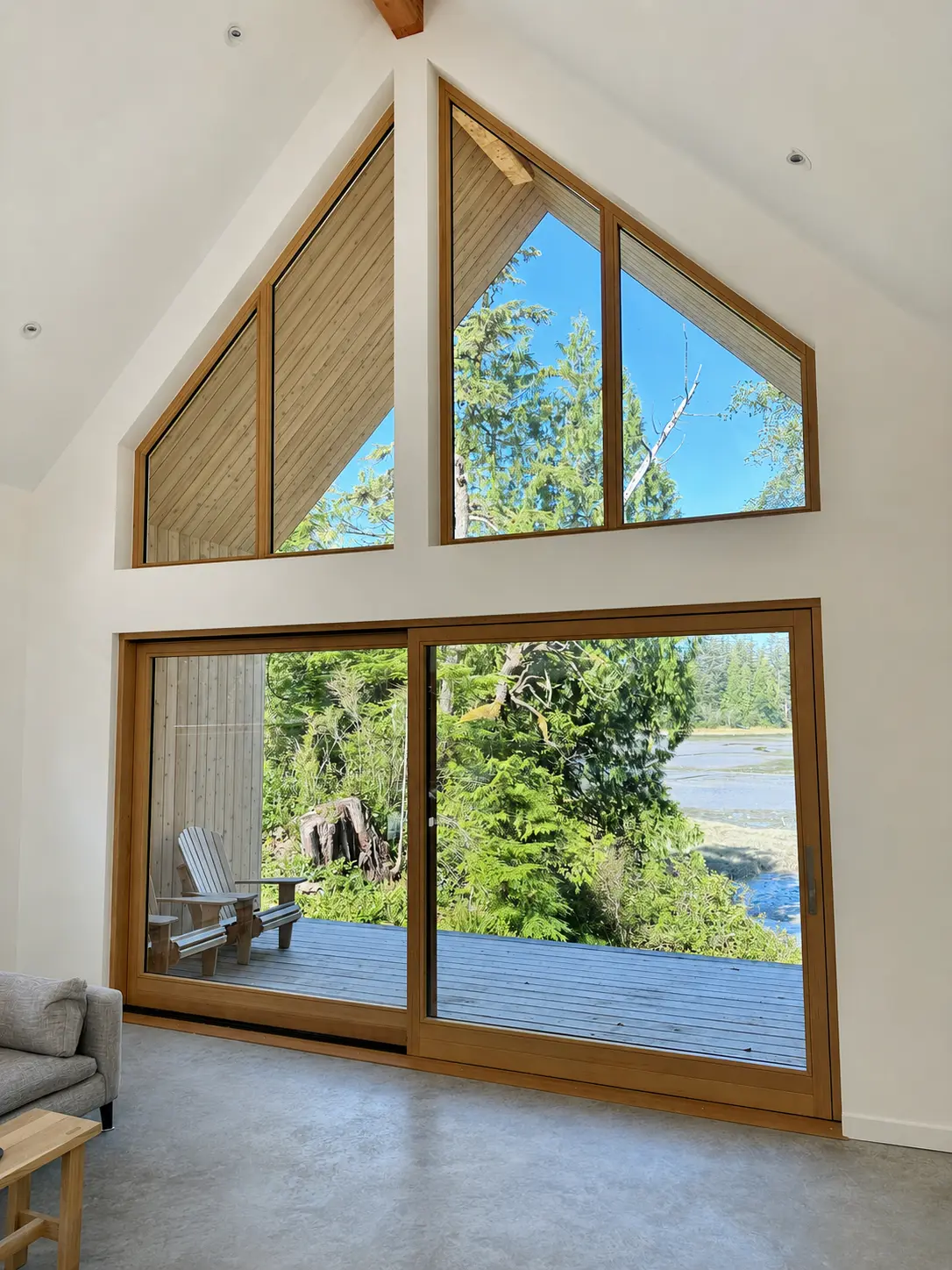 Finished Tofino interior with a pair of custom gable-shaped Fenstür windows above a lift-and-slide door