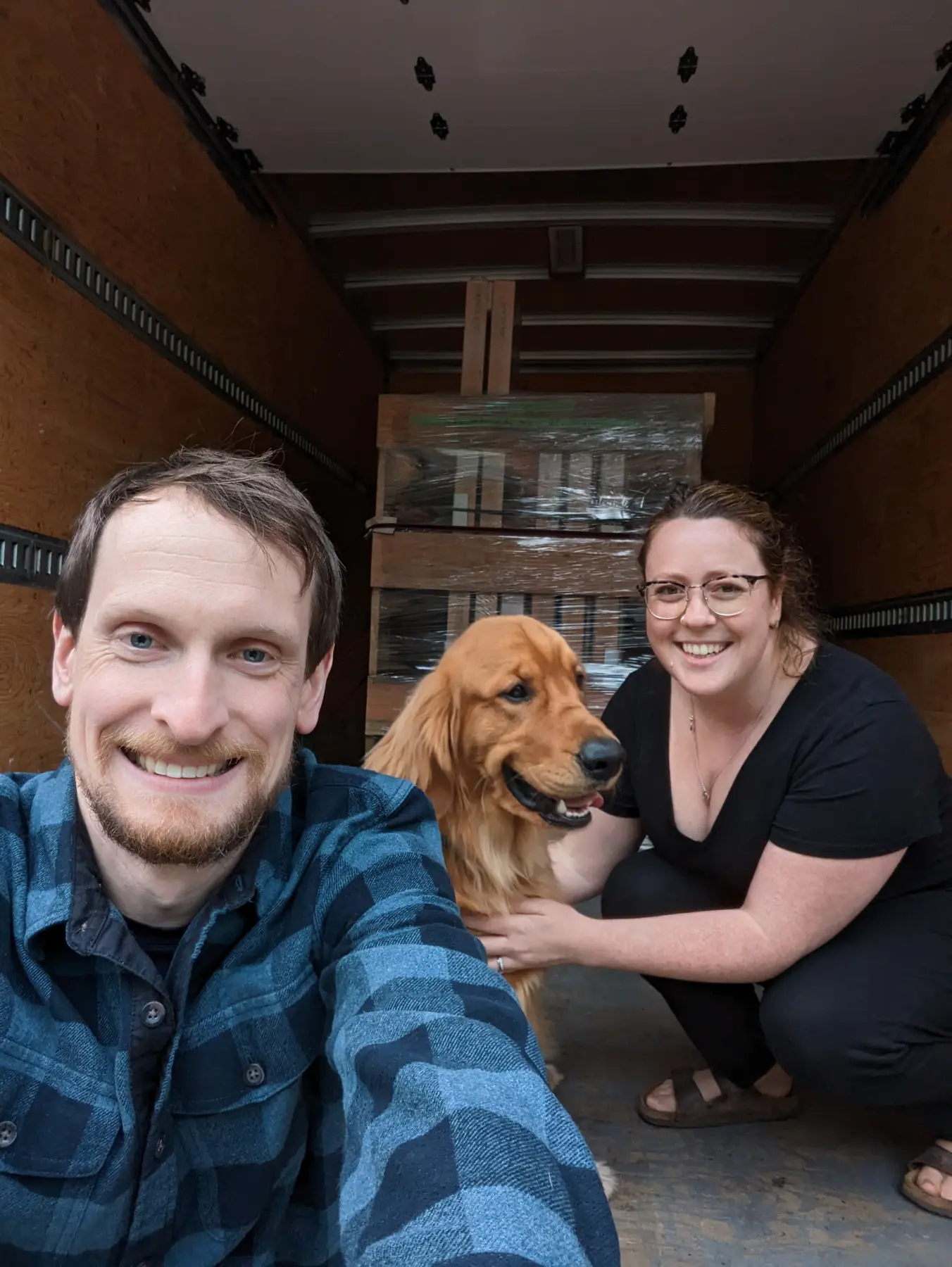 Smiling Fenstür customers with their dog beside carefully packed window crates