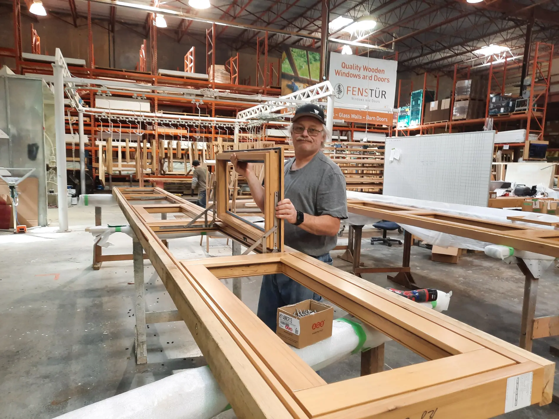 A Fenstür craftsperson assembling a custom wood window in the Duncan factory