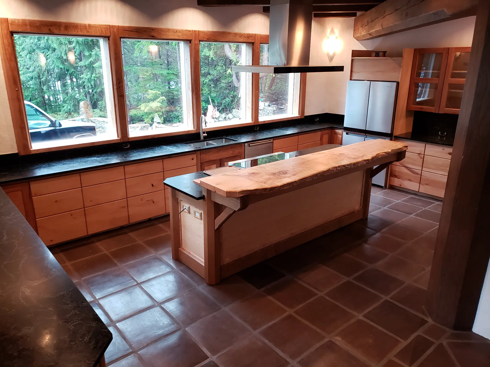Custom wood kitchen framed by a continuous row of Fenstür windows