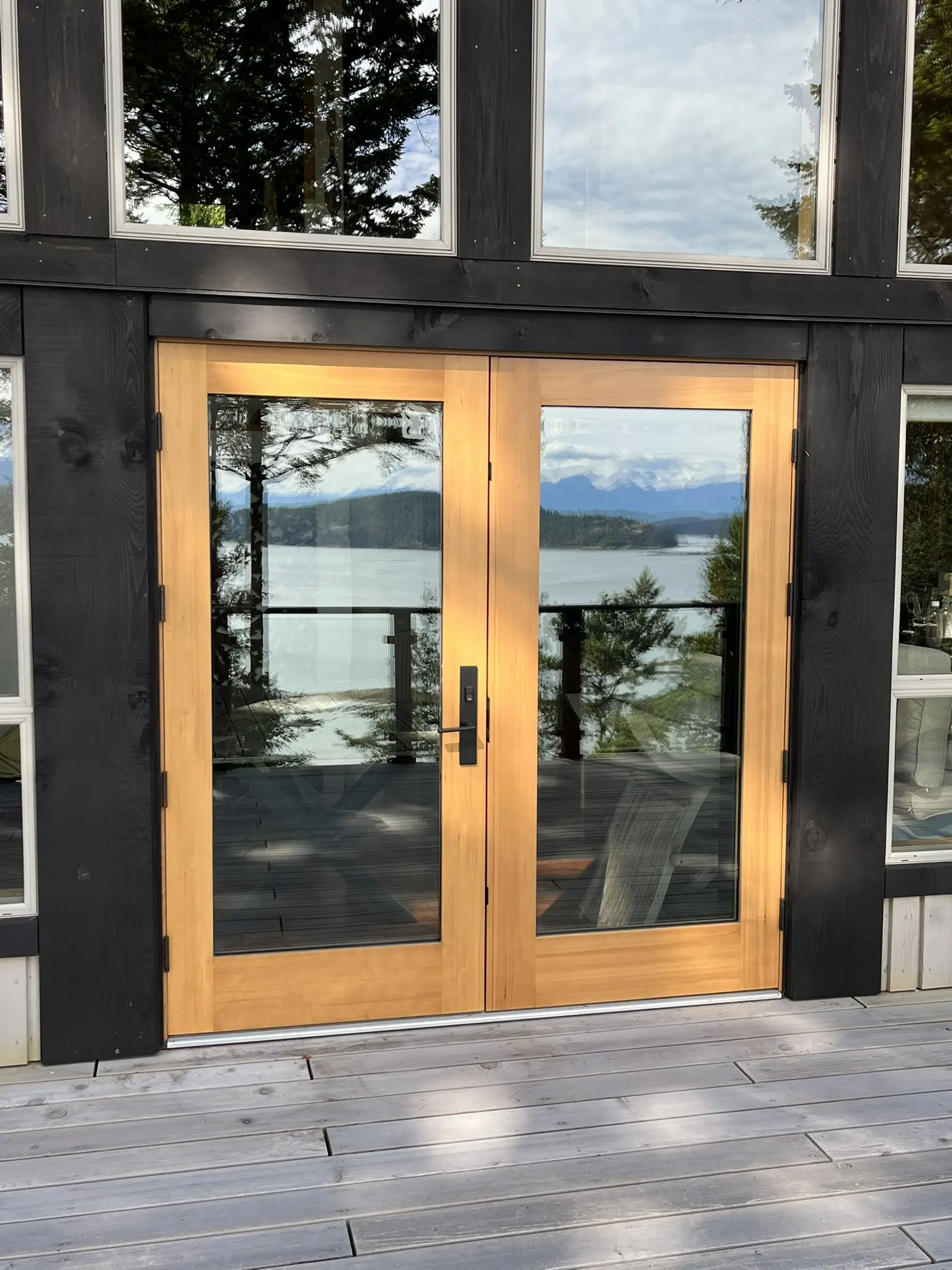 Glazed wood entry doors reflecting the Cortes Island shoreline