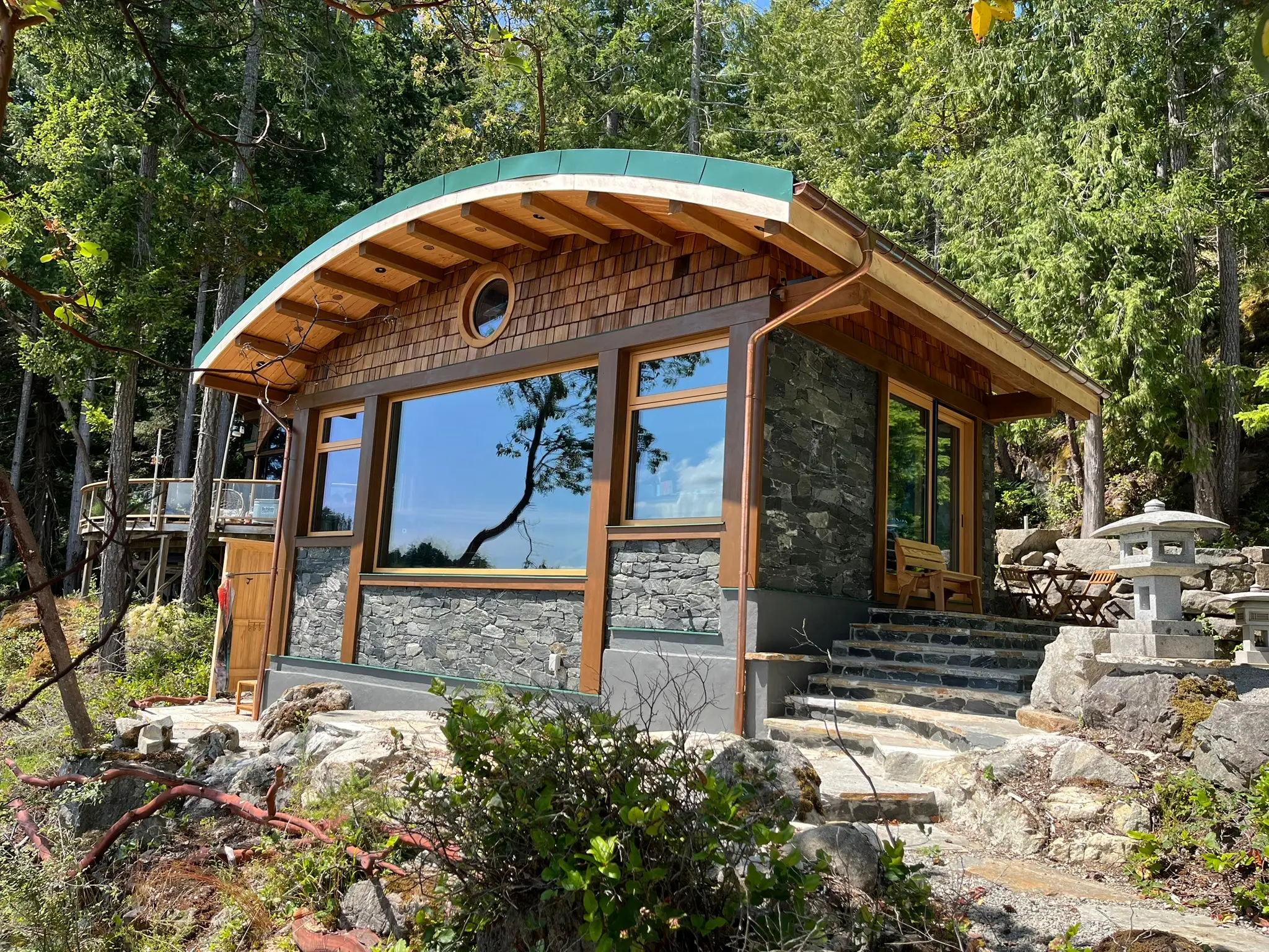 Finished curved-roof Cortes Island cottage with warm wood Fenstür windows