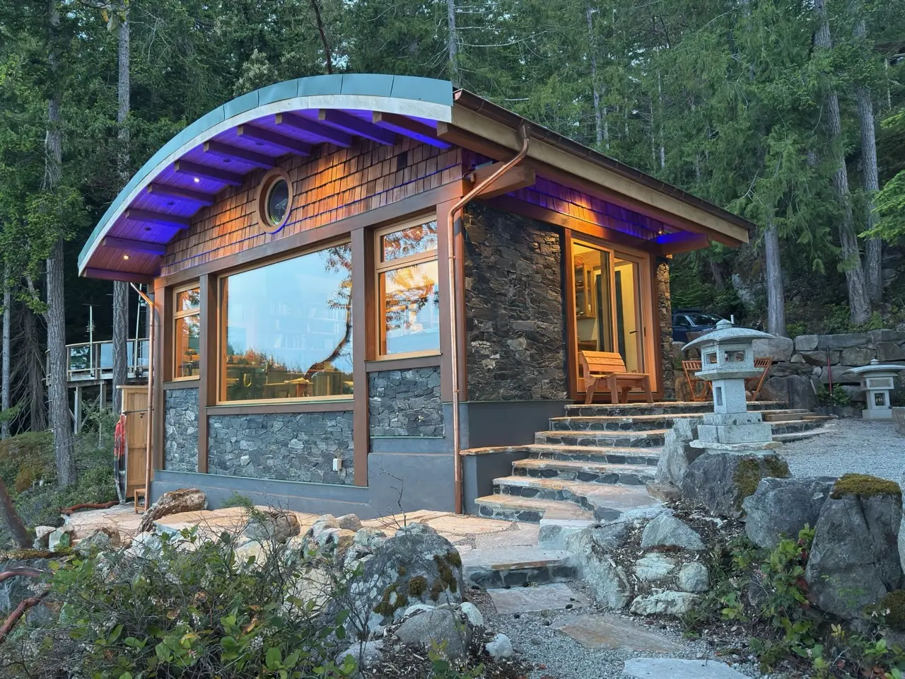 Cortes Island cottage at twilight with warm interior light