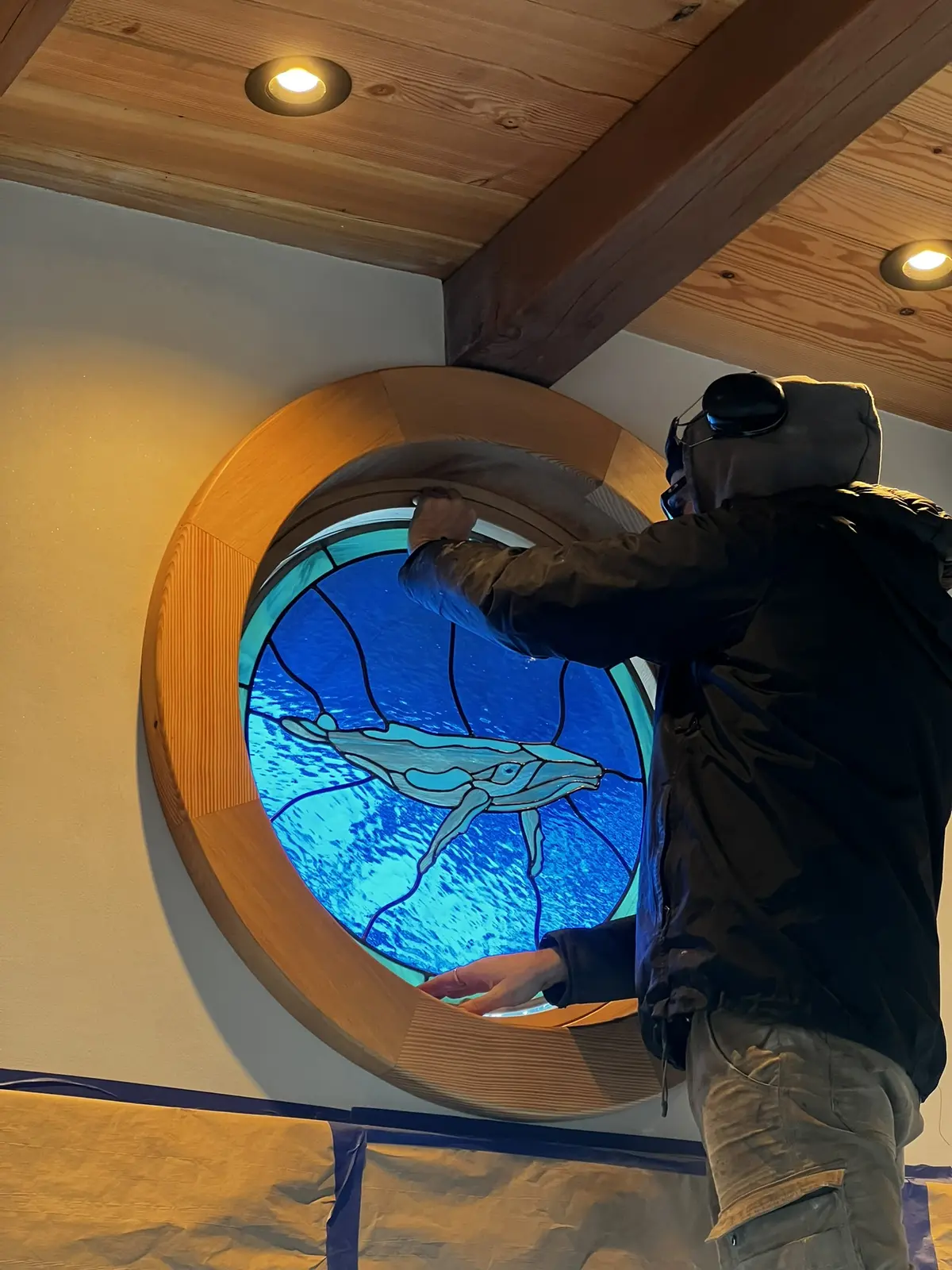 Interior installation of the custom round whale-glass window