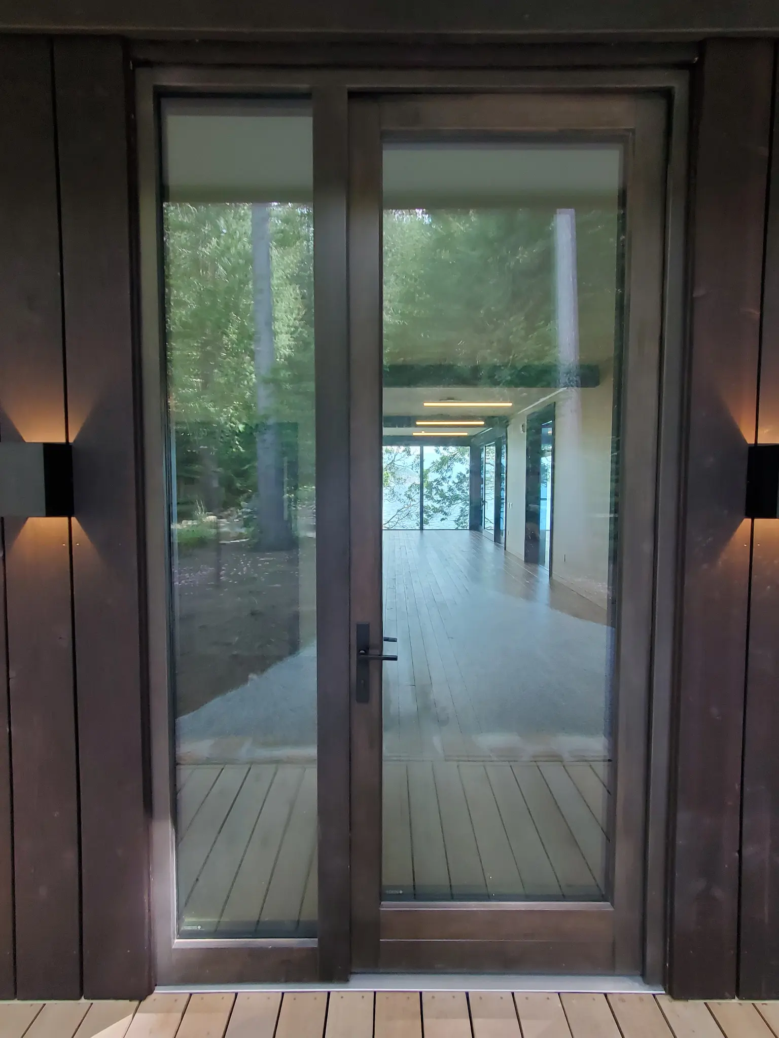 Slender glazed entrance door with matching sidelite and dark wood frame