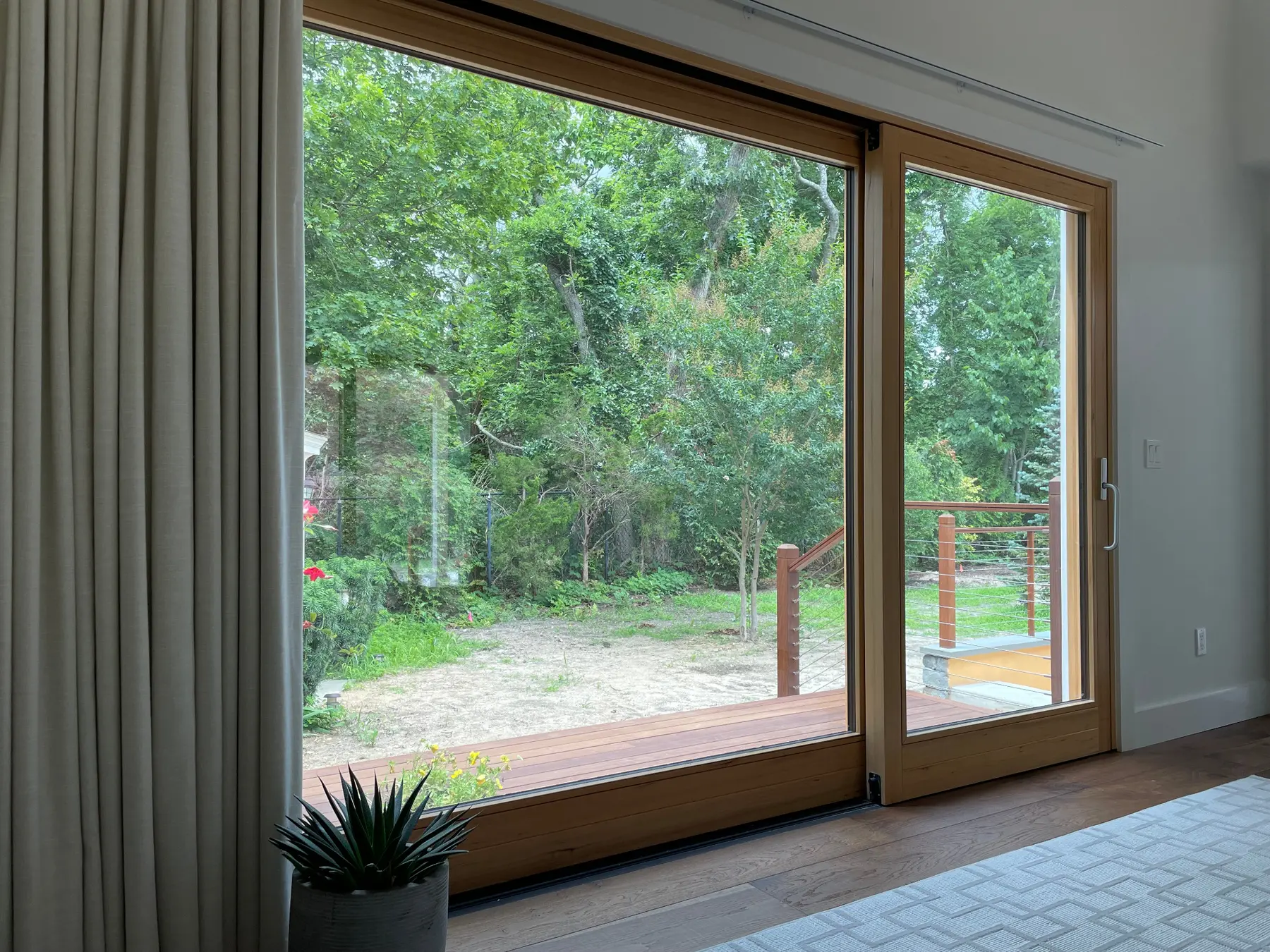 Full-height all-wood Fenstür Climatech lift-and-slide assembly opening a finished Hamptons room to the landscape