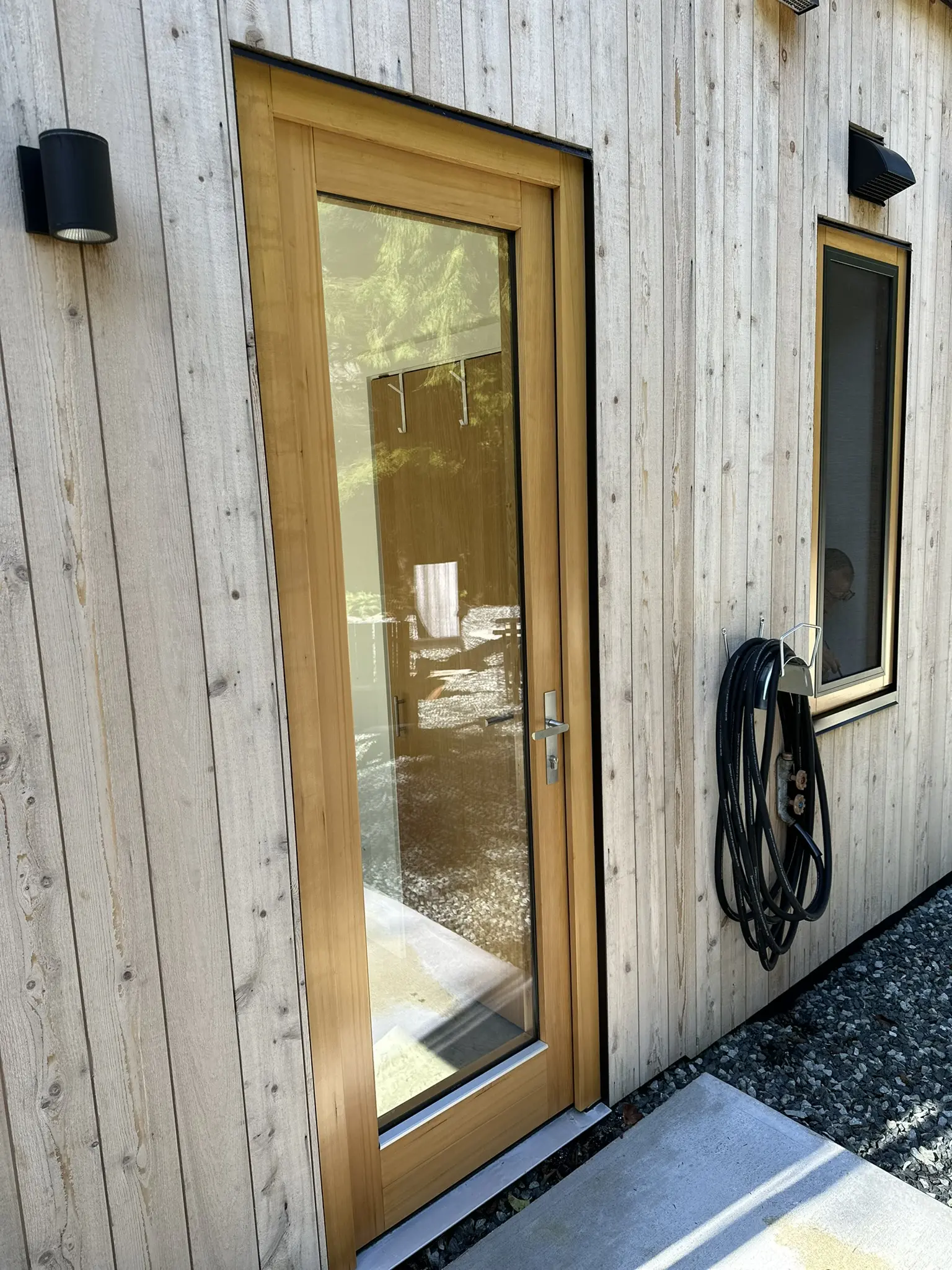 Narrow glazed wood door beside the service courtyard