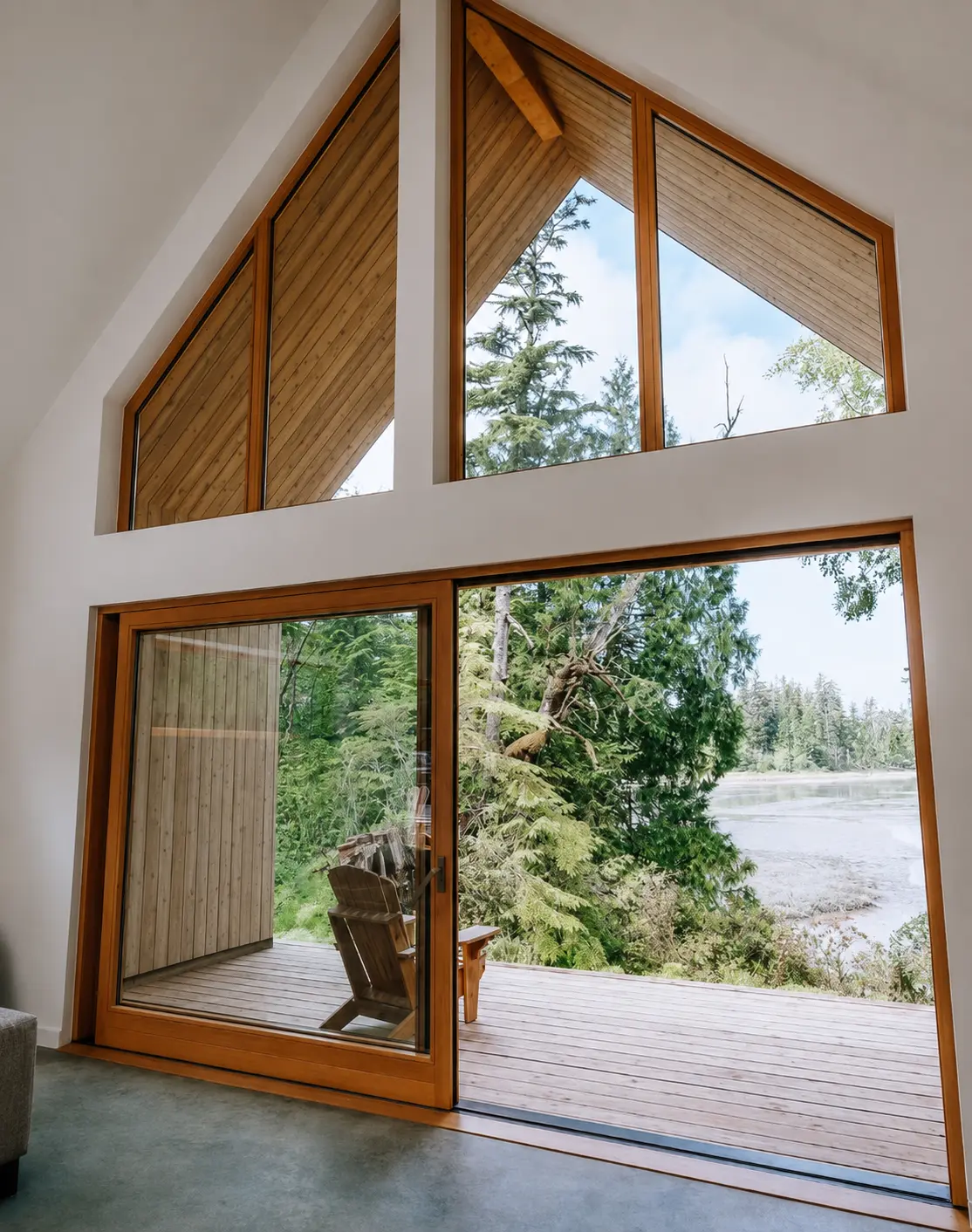 Open Fenstür lift-and-slide door beneath custom gable windows in a Tofino waterfront home