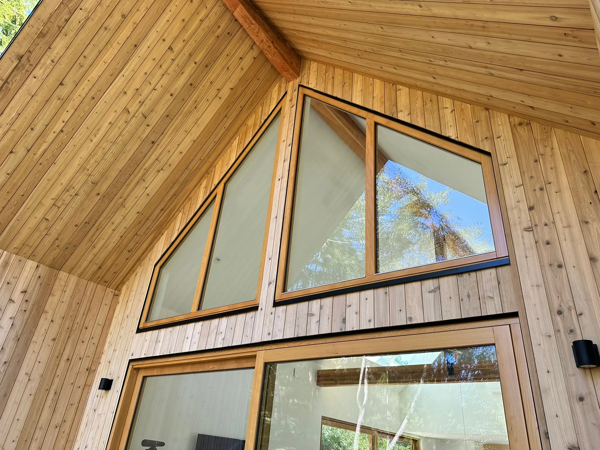 Custom rake-shaped picture windows beneath the timber roof