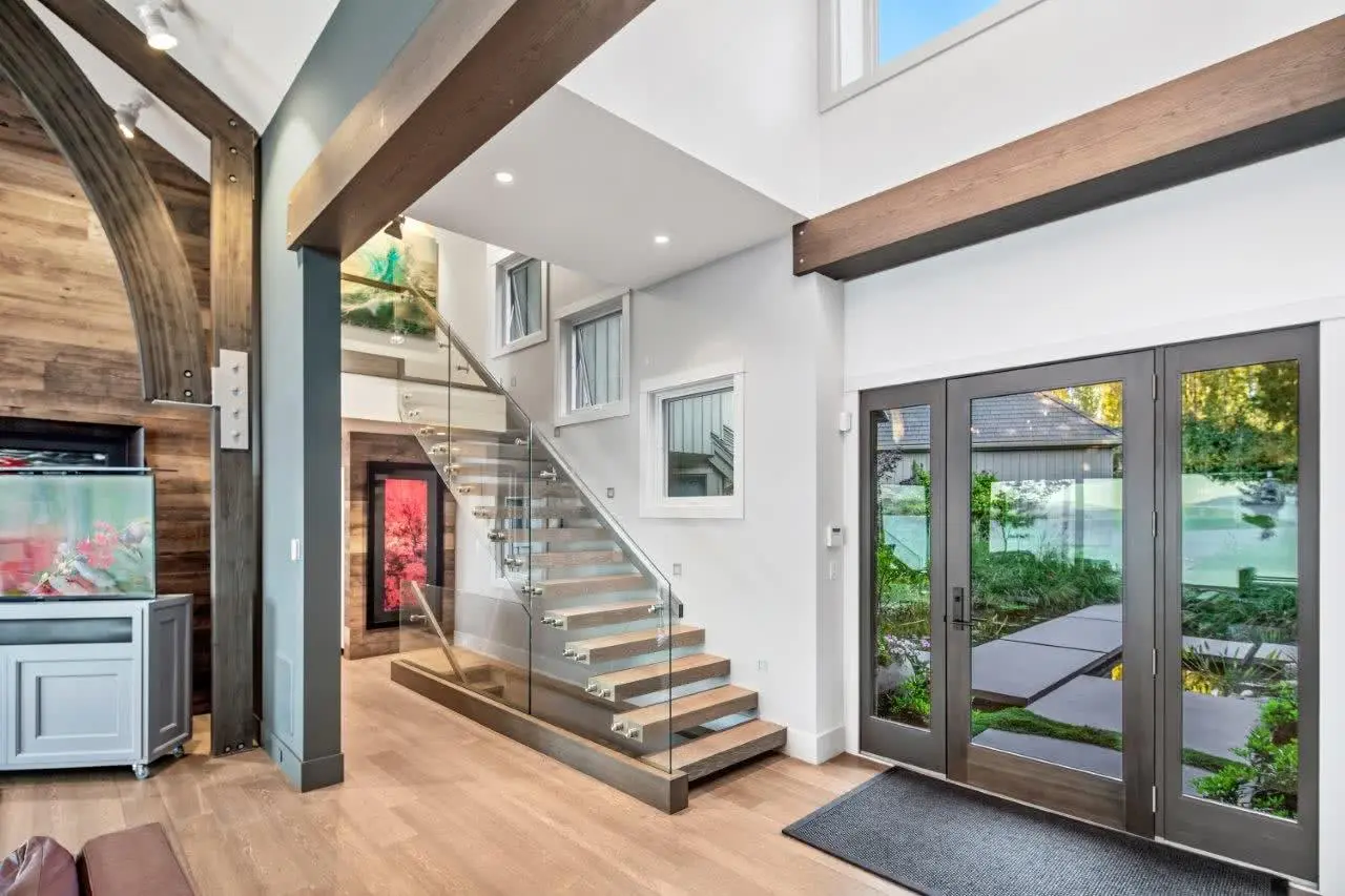 Custom glazed entrance doors beside the open stair